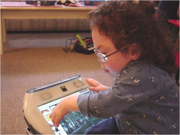 Krista accesses her SGD with a touch screen.